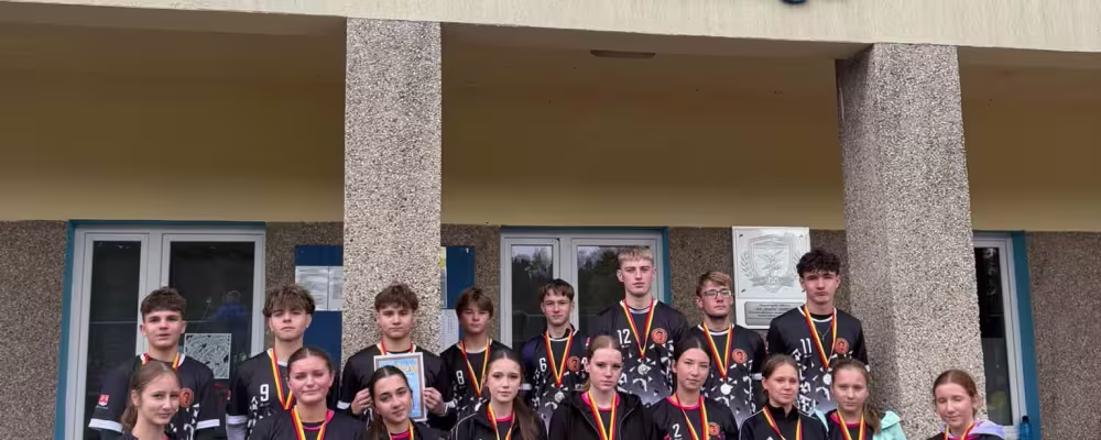 Drużyna sportowców z medalami przed Stadionem im. H. Puzonia w Zabrzegu. Fotografia.
